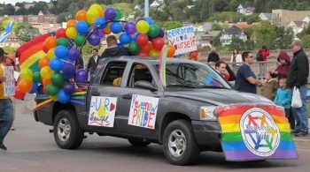 Truck decorated by Keweenaw Pride with a flag, signs, and balloons in the parade.
